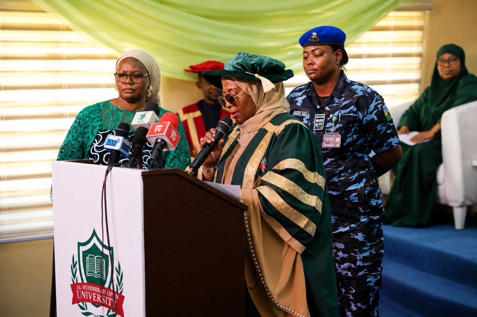 University official speaking at Al-Muhibbah Open University event with staff and attendees present.